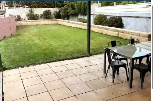 Secure grassed backyard and paved patio with outdoor dining setting at Cozy on Pearson, a pet friendly holiday home in Port Lincoln