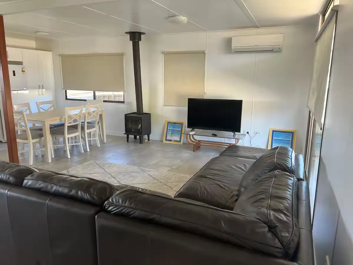 Open-plan living room at Cozy on Hudson with leather sofa, wood fireplace and TV