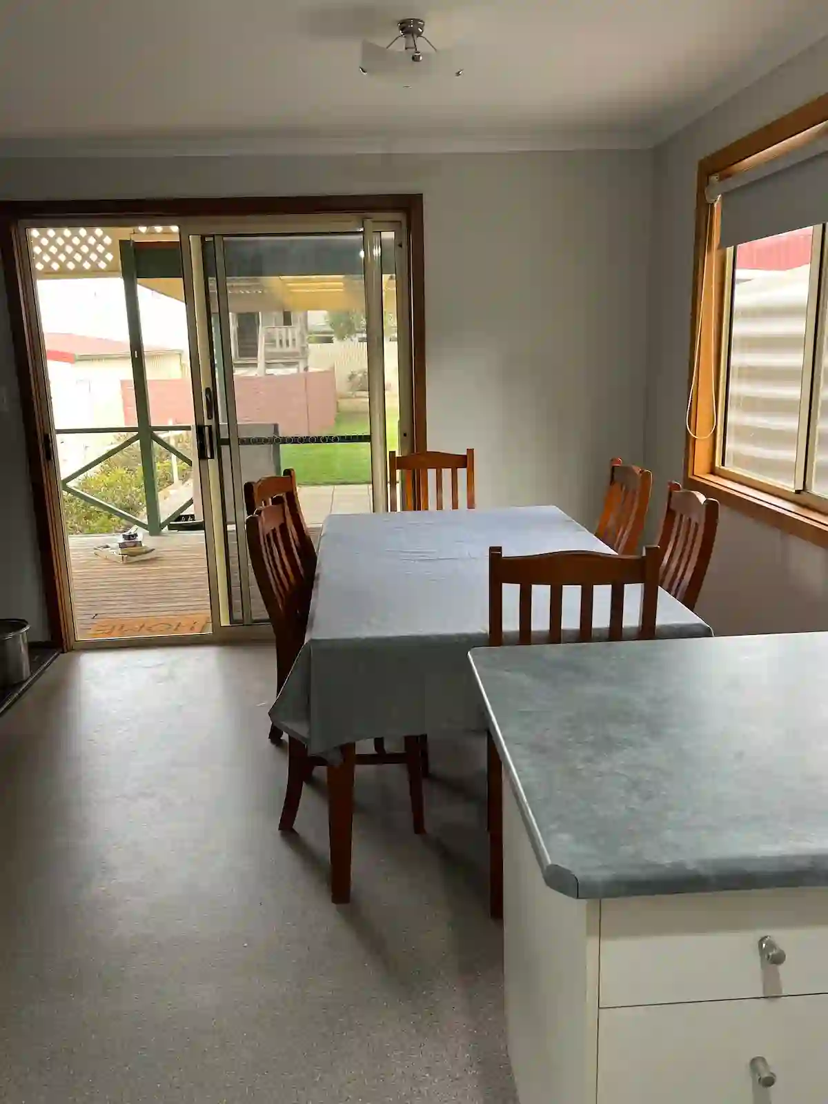 Dining area at Cozy on Pearson with a wooden table beside sliding doors to the deck